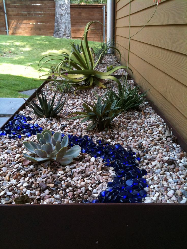 Steel planter with succulents, river rock and blue glass.